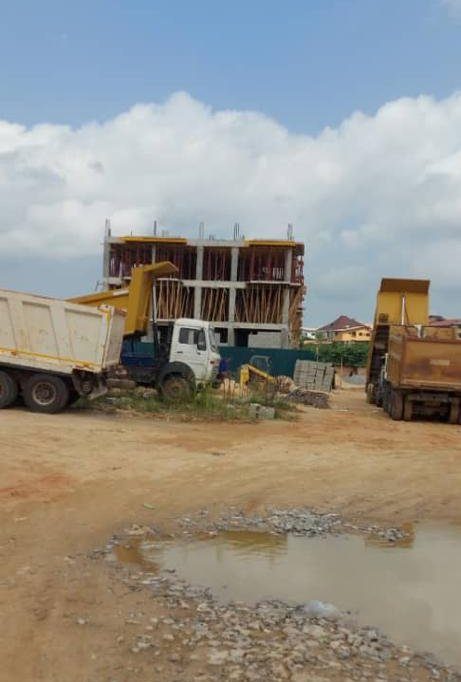 Tipper trucks and a partly formed structure at the Toll Heights site