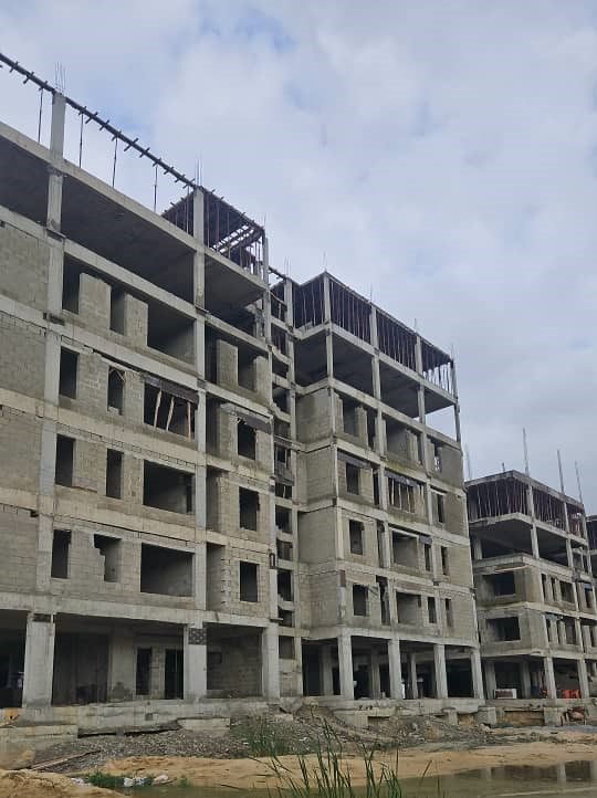 Concrete frames of the Toll Heights apartment blocks rising beside the waterfront